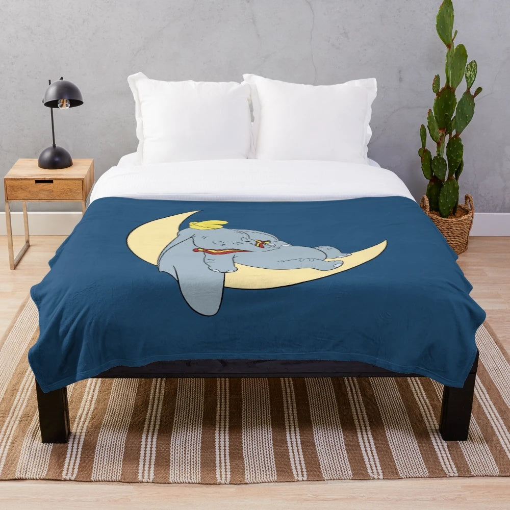 Soft and cuddly plush blanket featuring Dumbo the elephant and the moon, perfect for a cozy and cute bedroom or nursery decor