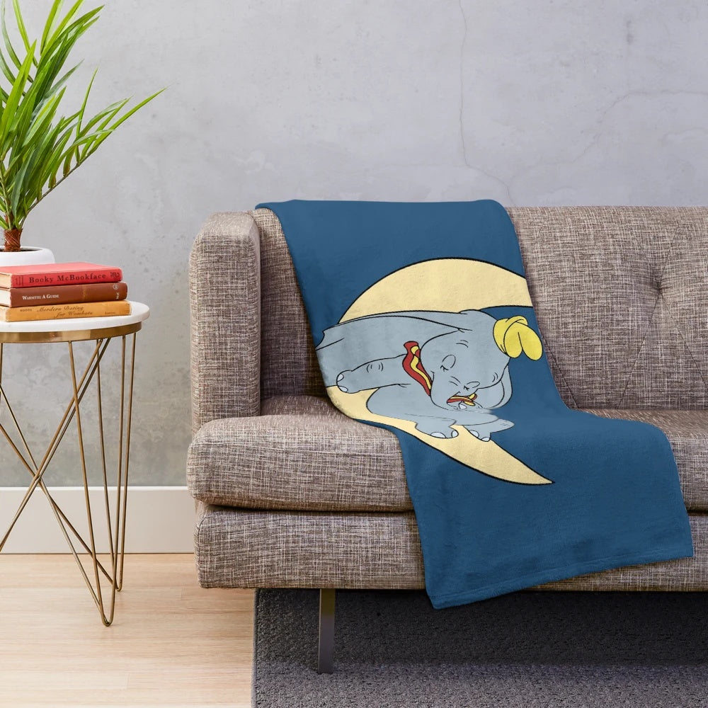 Soft and cuddly plush blanket featuring Dumbo the elephant and the moon, perfect for a cozy and cute bedroom or nursery decor