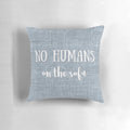 A gray and white decorative pillow with a playful "No Humans on the Sofa" dog-themed design.