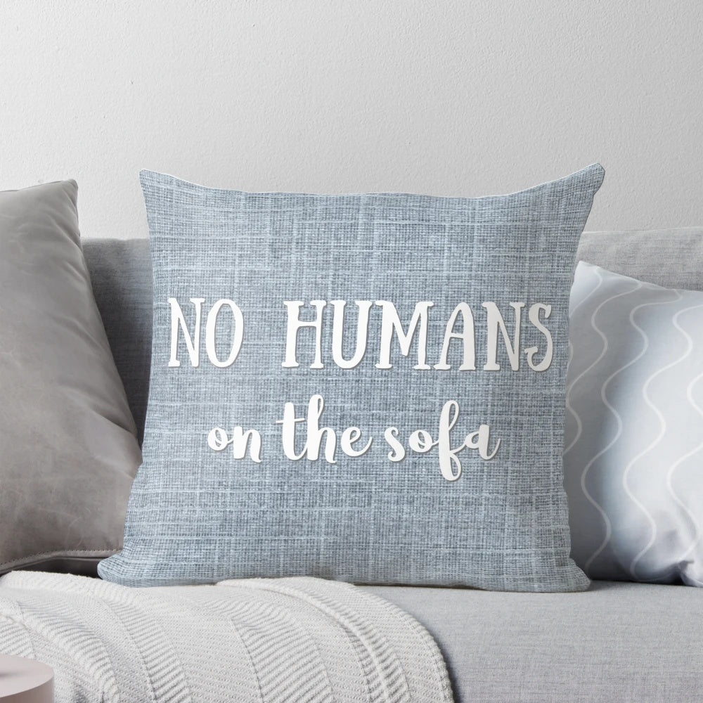 A gray and white decorative pillow with a playful "No Humans on the Sofa" dog-themed design.