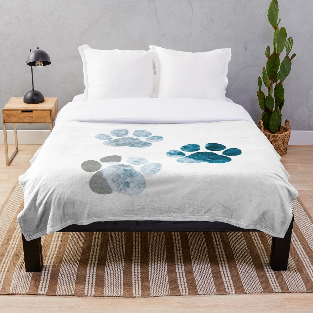 Dog paw prints design on a plush, cozy blanket with beach waves and sand motif