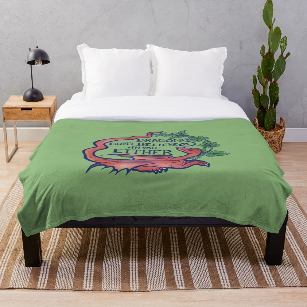 Plush dragon-themed blanket with "Dragons don't believe in you either" design