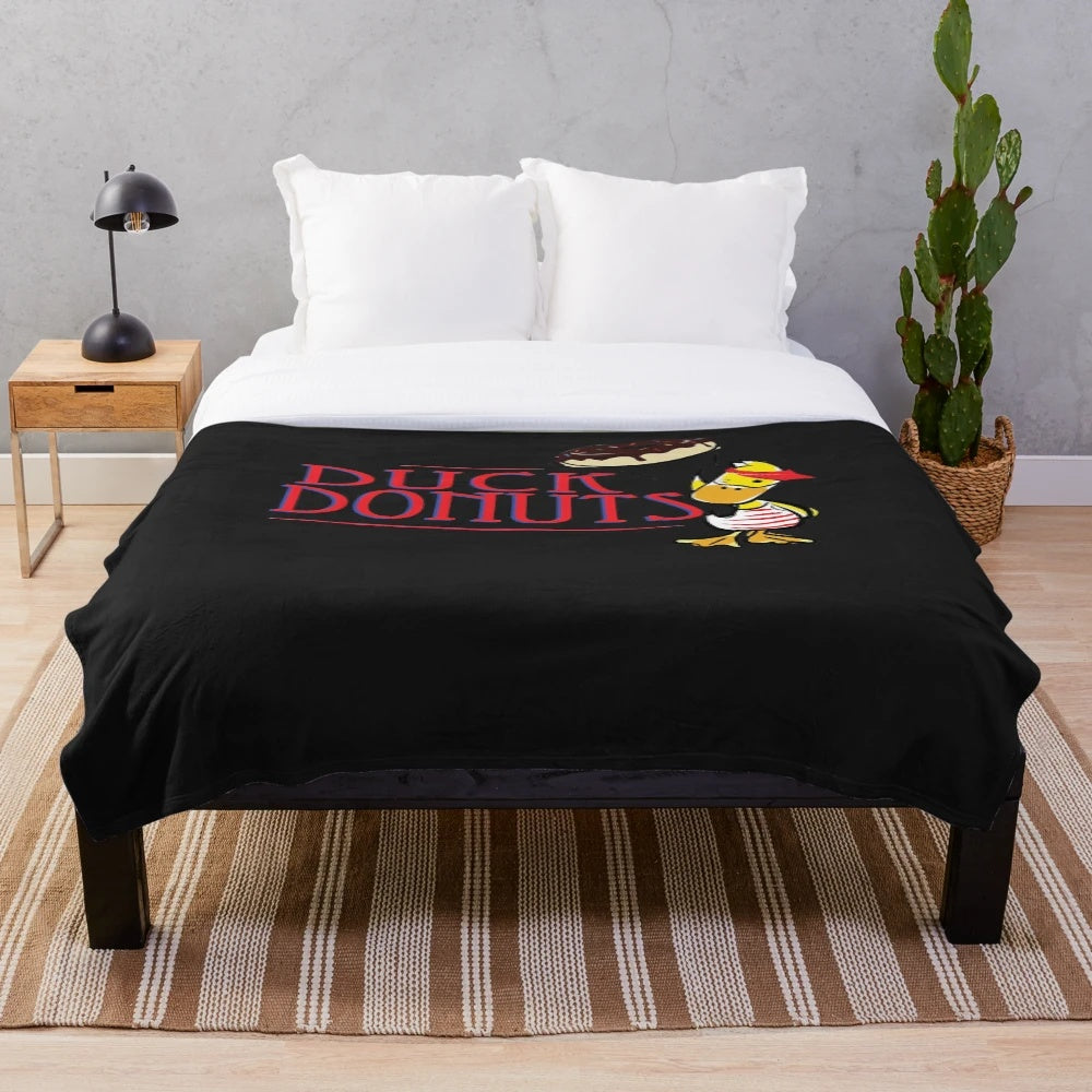Plush blanket featuring a duck and doughnuts design