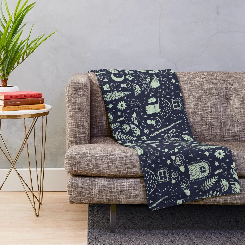 Plush blanket featuring a fairy garden design with mushrooms, butterflies, and flowers in a midnight theme