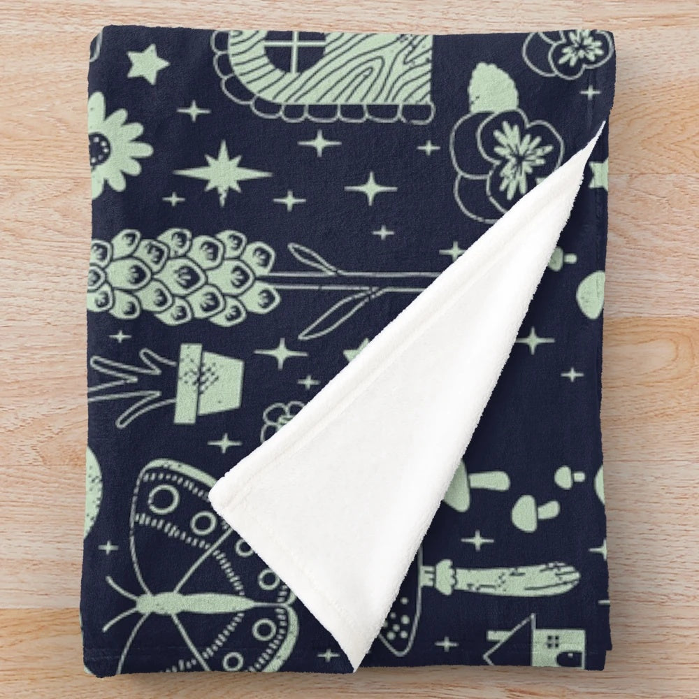 Plush blanket featuring a fairy garden design with mushrooms, butterflies, and flowers in a midnight theme