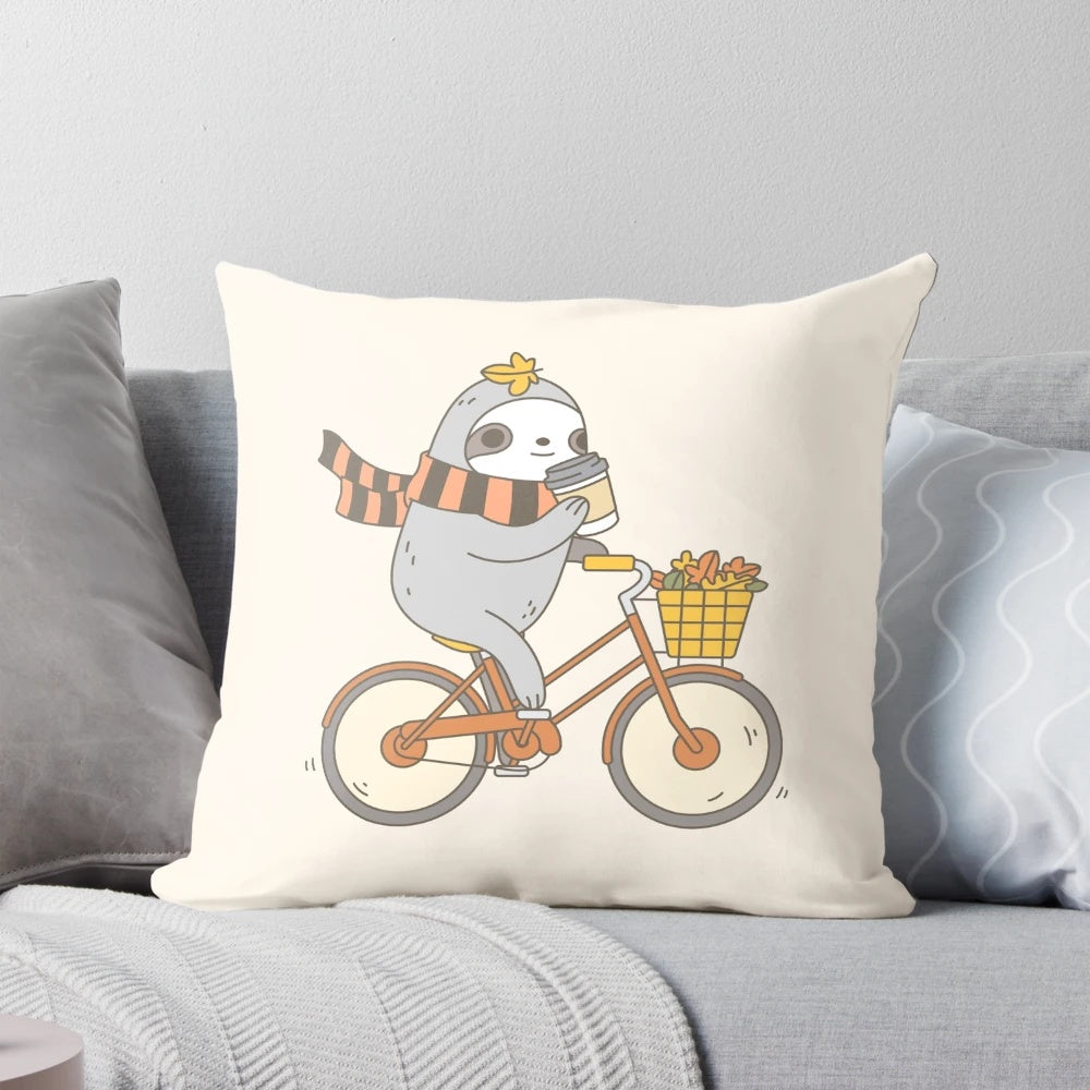A plush, autumn-themed pillow featuring a cute and whimsical sloth riding a bike, perfect for home decor or gift-giving.