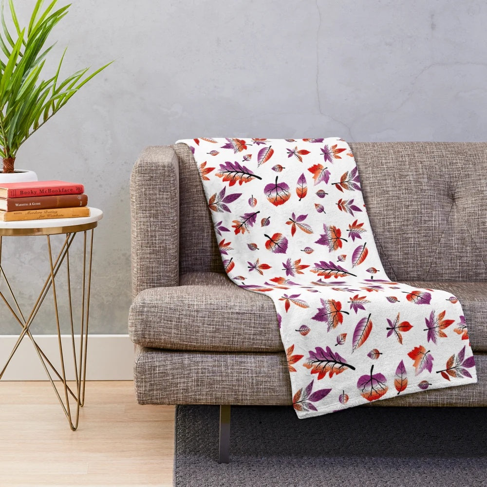 Plush blanket featuring fall leaves in pastel purple, pink, and orange colors representing the lesbian pride flag