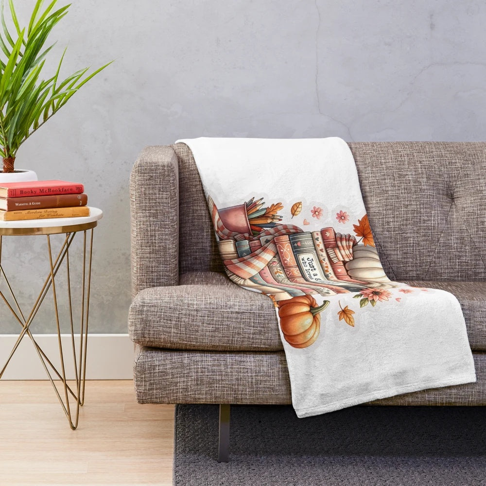 Plush fall-themed blanket with leaves, pumpkins, and other autumn elements