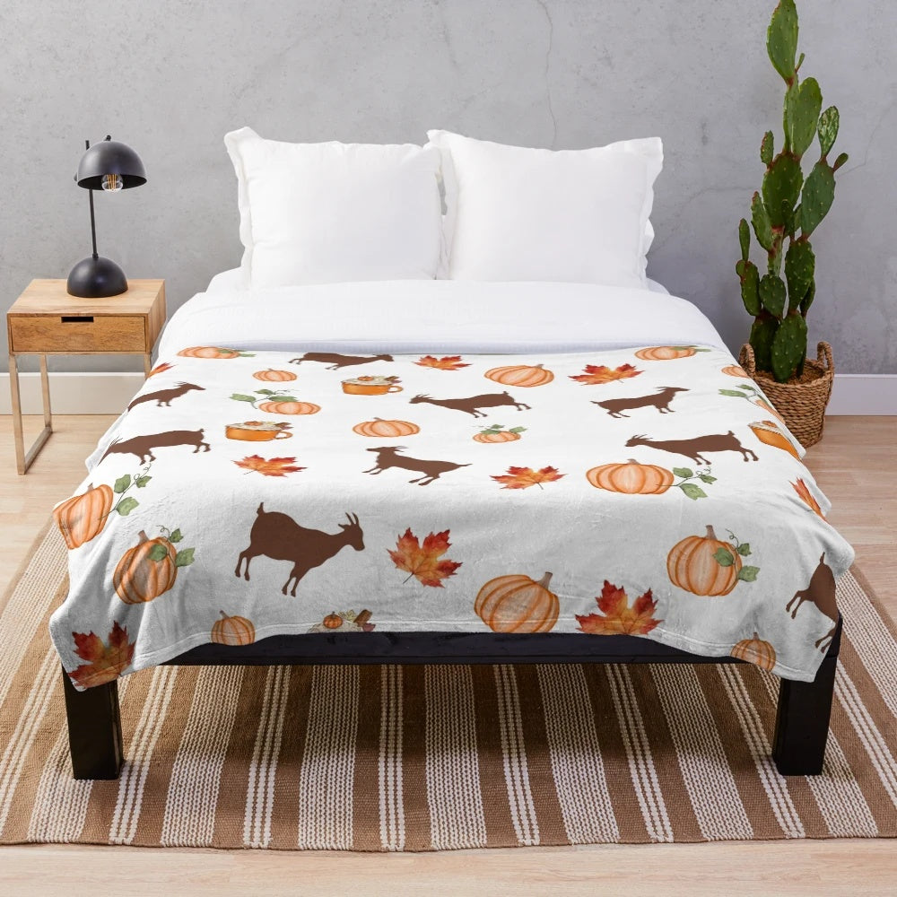 Plush blanket with autumn themed design of pumpkins, goats, and maple leaves