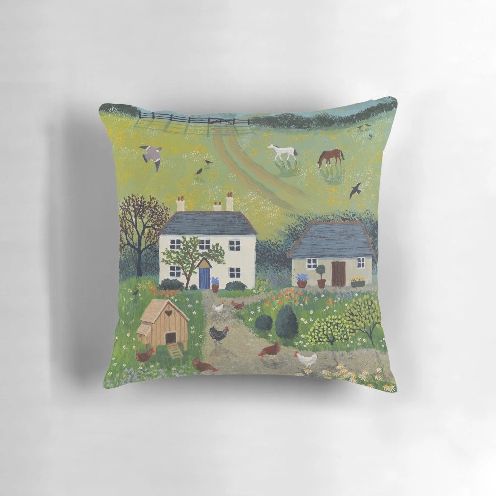 A decorative pillow featuring a charming country scene with chickens, horses, and a white cottage surrounded by a rural landscape.