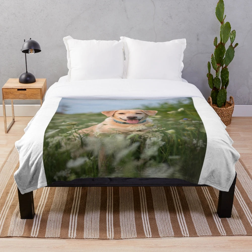A plush blanket featuring a cute Labrador puppy in a field of flowers