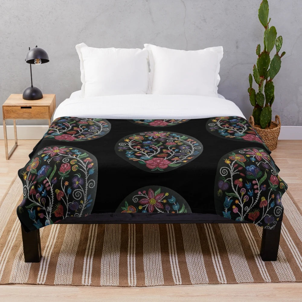 Cozy plush blanket with floral design in shades of rose, red, pink, orange, and green