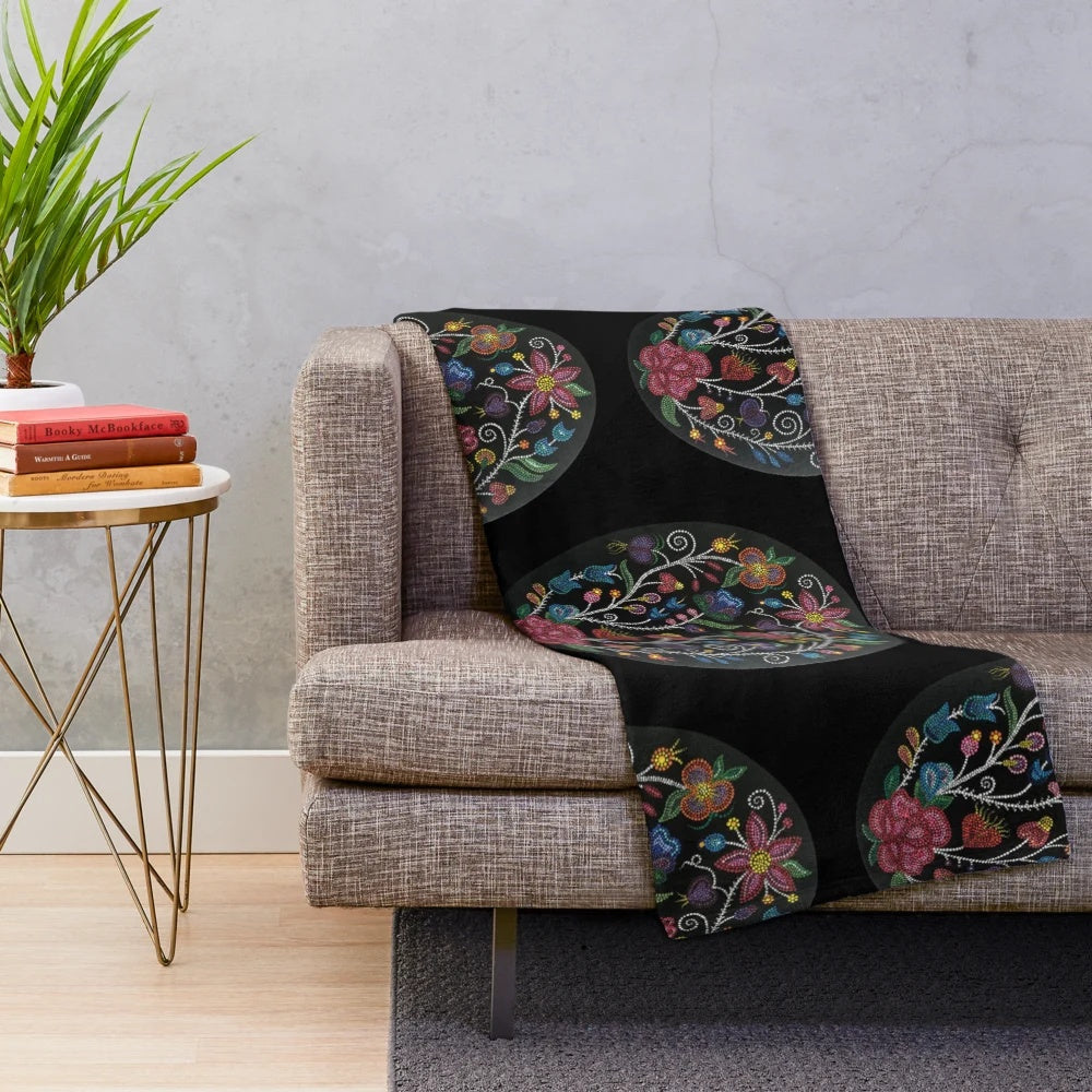 Cozy plush blanket with floral design in shades of rose, red, pink, orange, and green