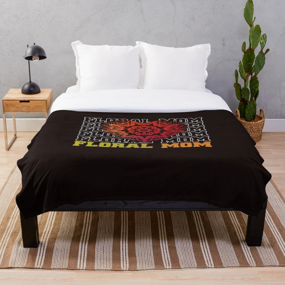 A soft and plush floral-patterned blanket featuring a heartwarming mom quote