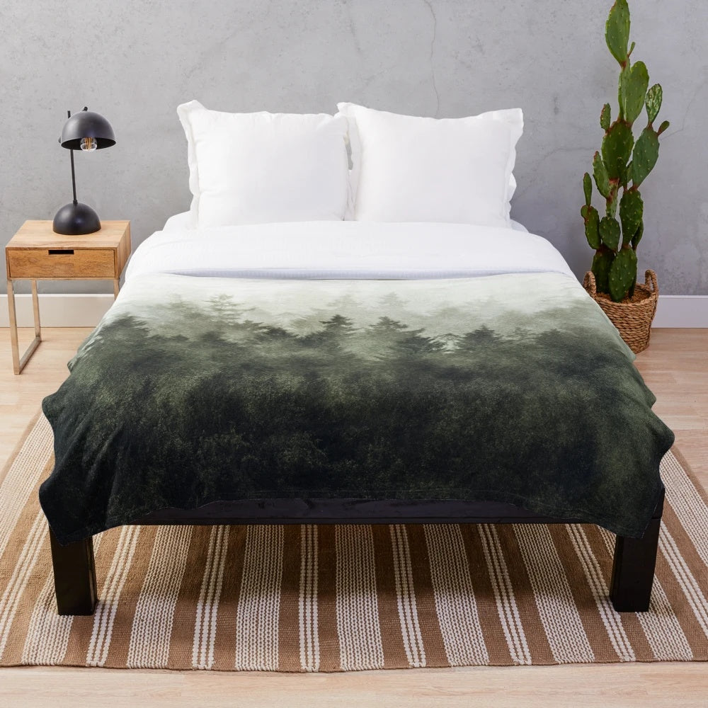 Plush blanket with a scenic forest landscape design