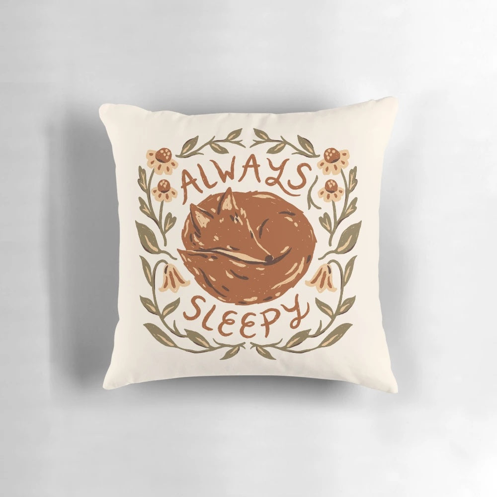 A cozy fox-themed decorative pillow with floral design and inspirational handlettering