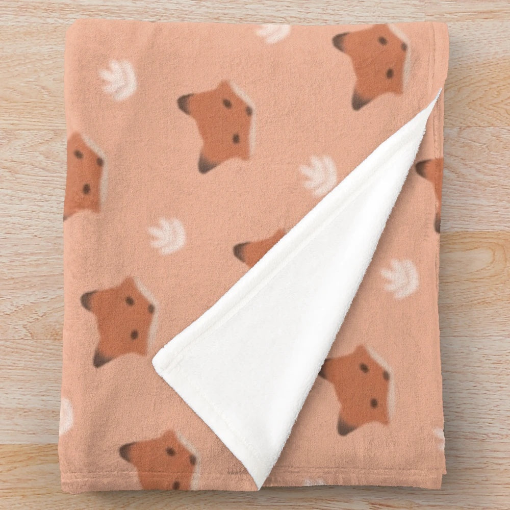 A soft and plush fox print blanket in warm neutral colors.
