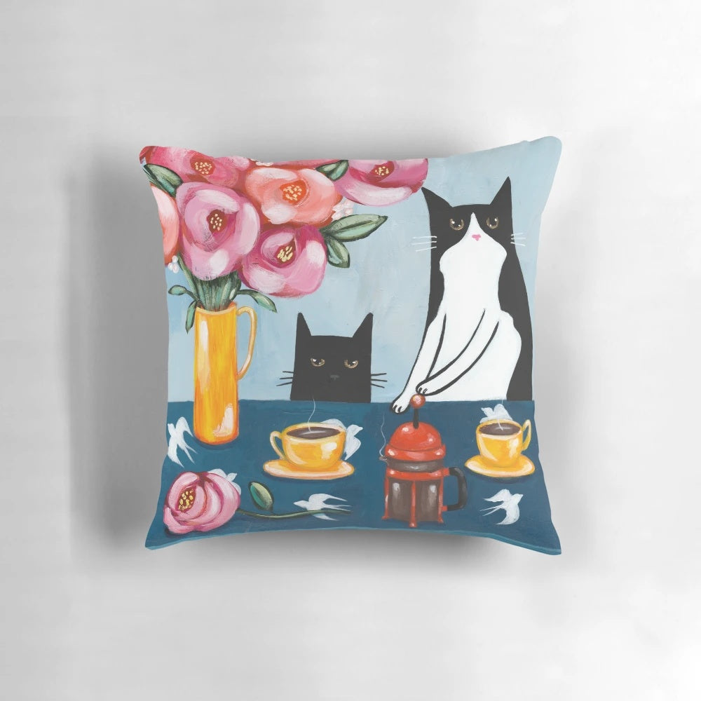 A soft, plush pillow featuring a tuxedo cat enjoying a french press coffee