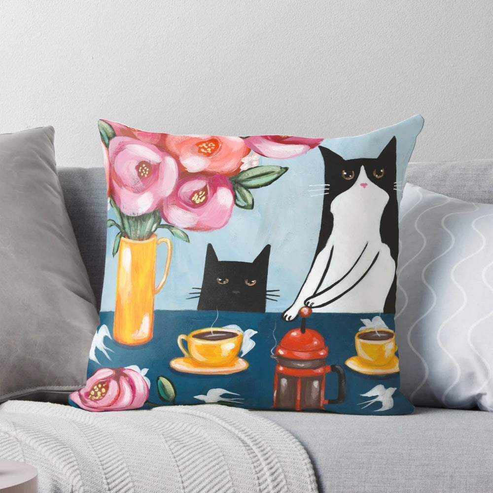 A soft, plush pillow featuring a tuxedo cat enjoying a french press coffee