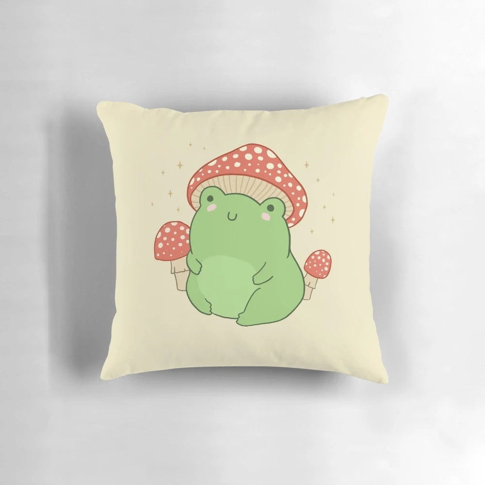Soft, plush pillow featuring a cute, chubby frog wearing a whimsical mushroom hat, perfect for a cottagecore or forest-themed room decor.