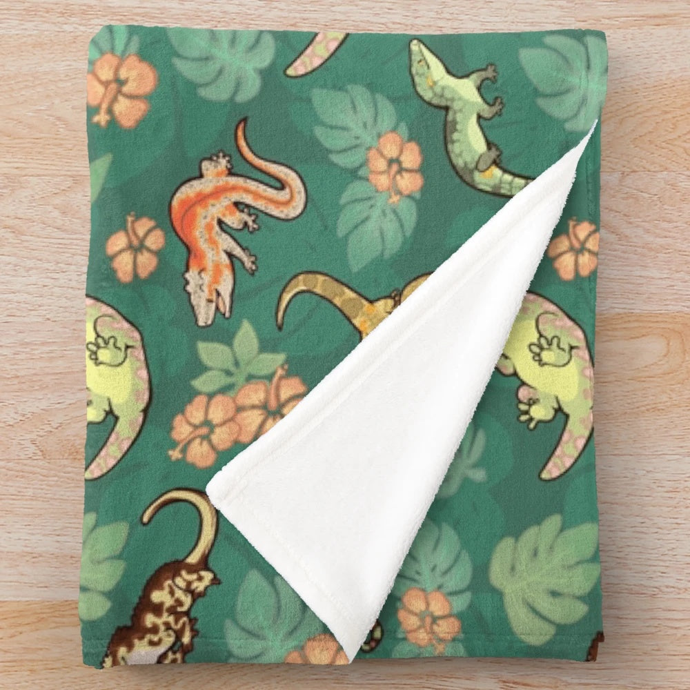 Vibrant green plush blanket featuring a family of geckos