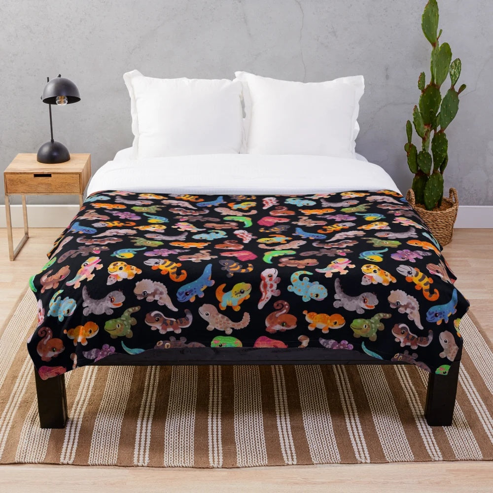 Dark-colored plush blanket with gecko/lizard design