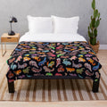 Dark-colored plush blanket with gecko/lizard design
