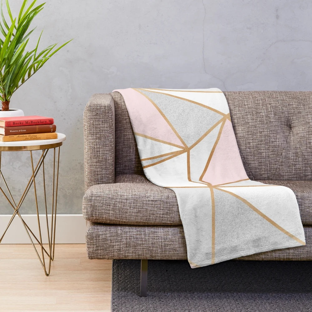 Soft and plush geometric patterned blanket in pink, grey, and gold colors