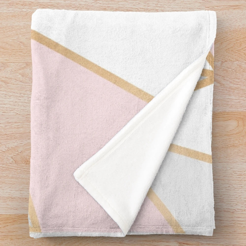 Soft and plush geometric patterned blanket in pink, grey, and gold colors