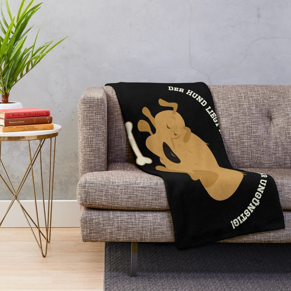 Plush blanket depicting a dog lying in an inconvenient way, inspired by the popular German comedy series Loriot