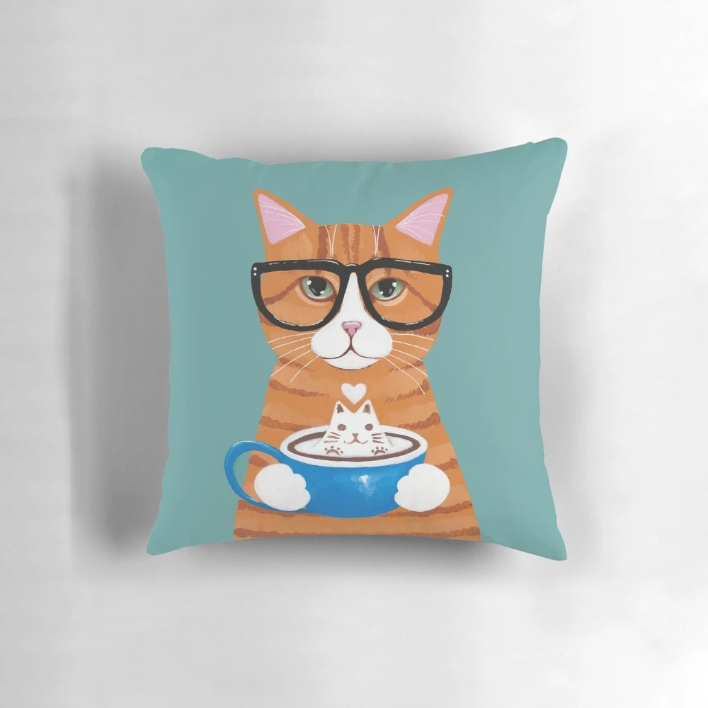 A charming ginger cat wearing glasses and sipping on a cappuccino, depicted on a decorative throw pillow.