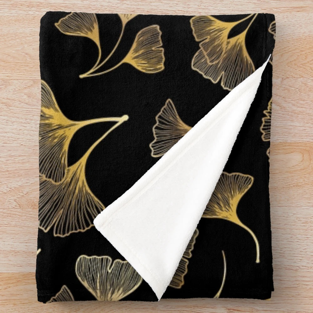 Closeup of a plush blanket with a golden leaf pattern