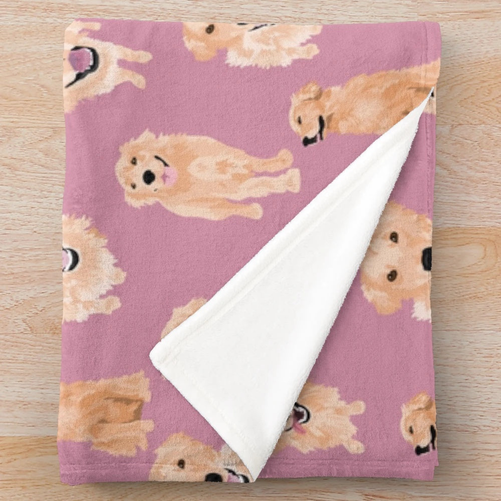 Golden retriever puppies on a soft pink plush blanket