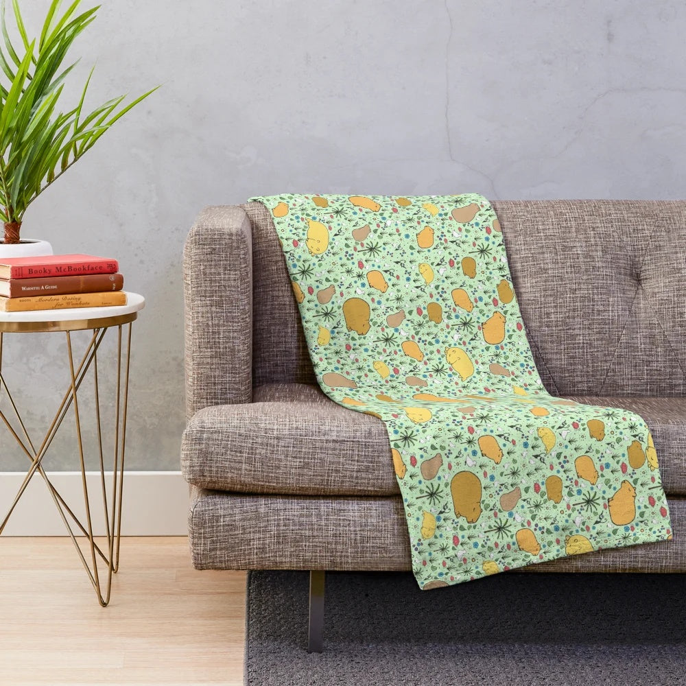 Soft and cuddly green plush blanket featuring adorable capybara design