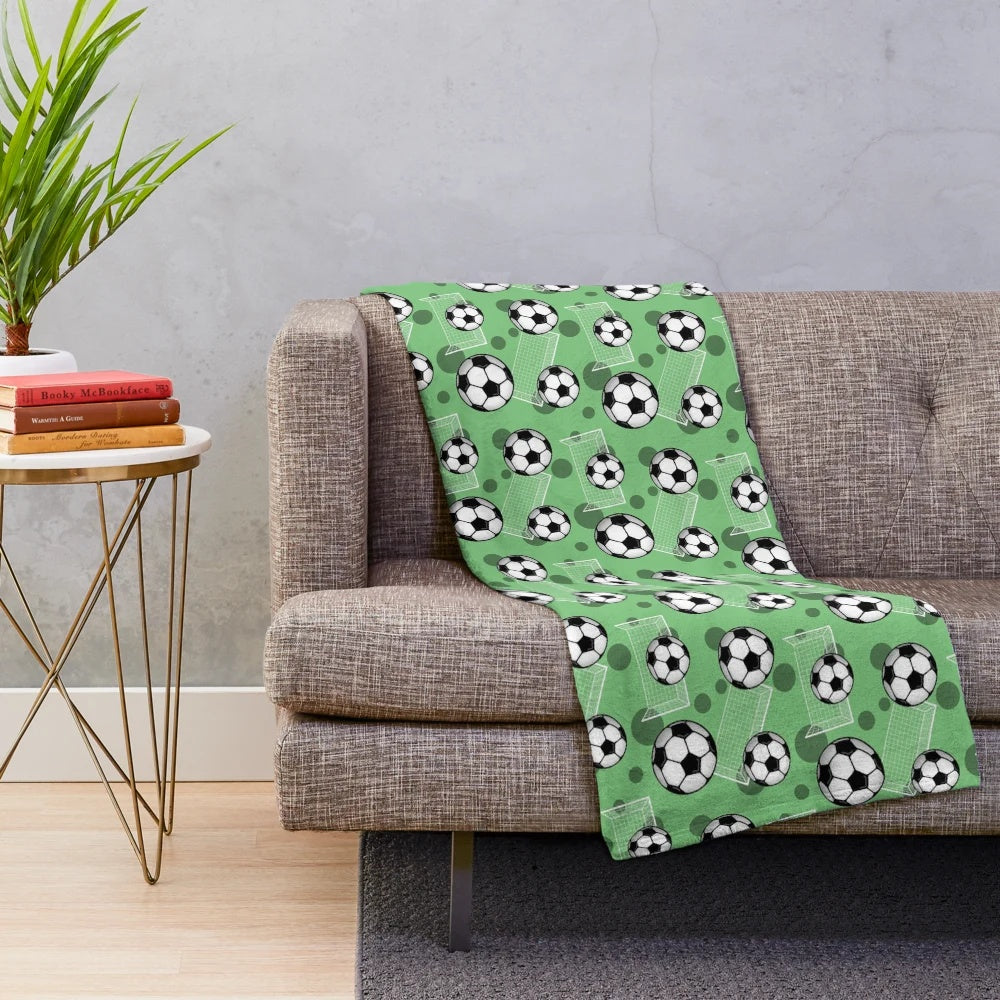 Green soccer pattern plush blanket with soccer ball and goal design