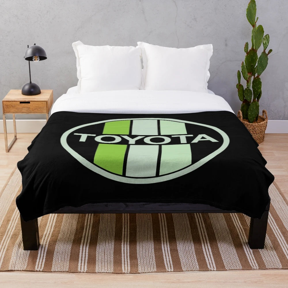 Green Toyota-inspired plush blanket with circular patterns