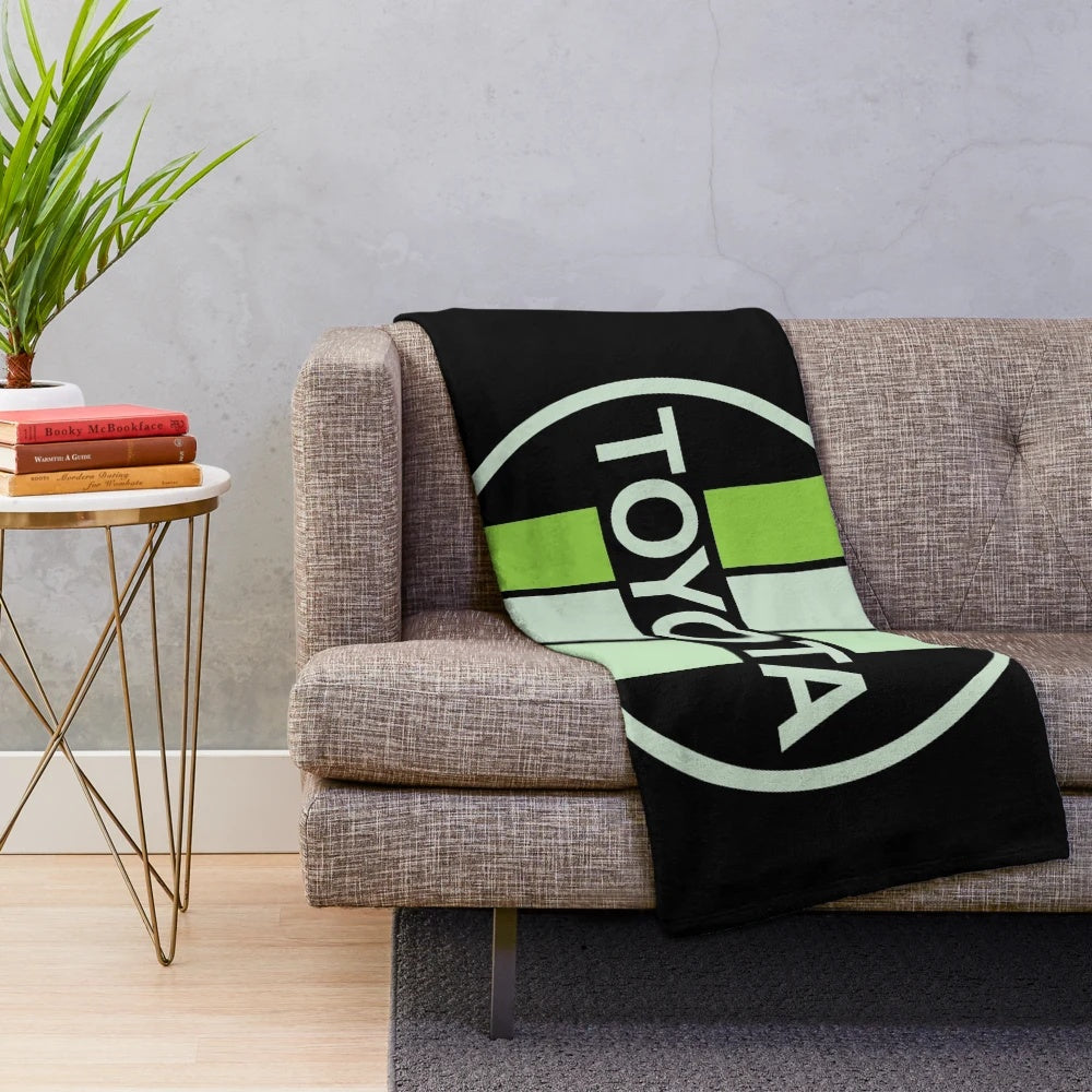 Green Toyota-inspired plush blanket with circular patterns