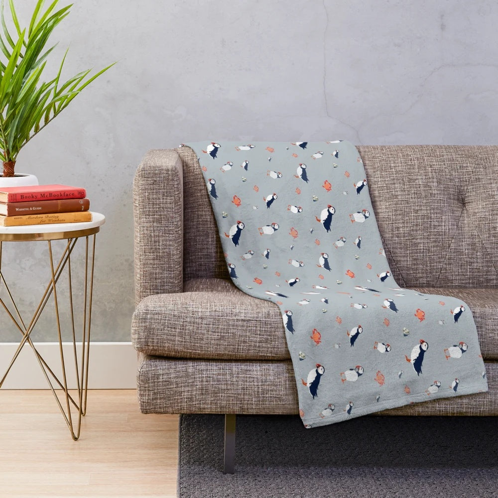Grey plush blanket with a whimsical puffin bird pattern
