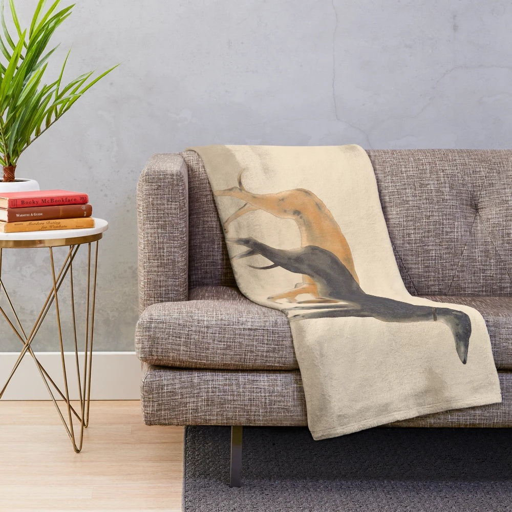 Two greyhounds cuddling on a plush grey and white blanket