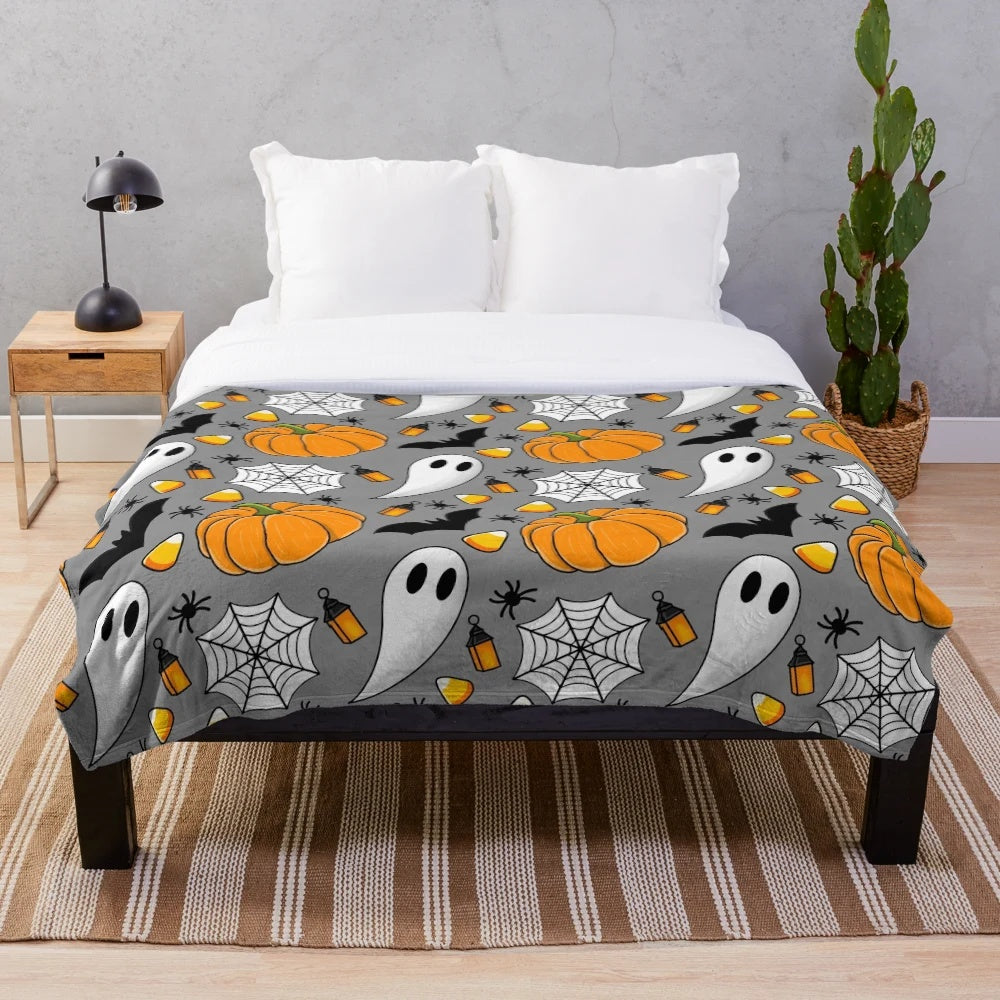 Cozy Halloween patterned plush blanket with pumpkin, spider web, candy corn, and other spooky designs