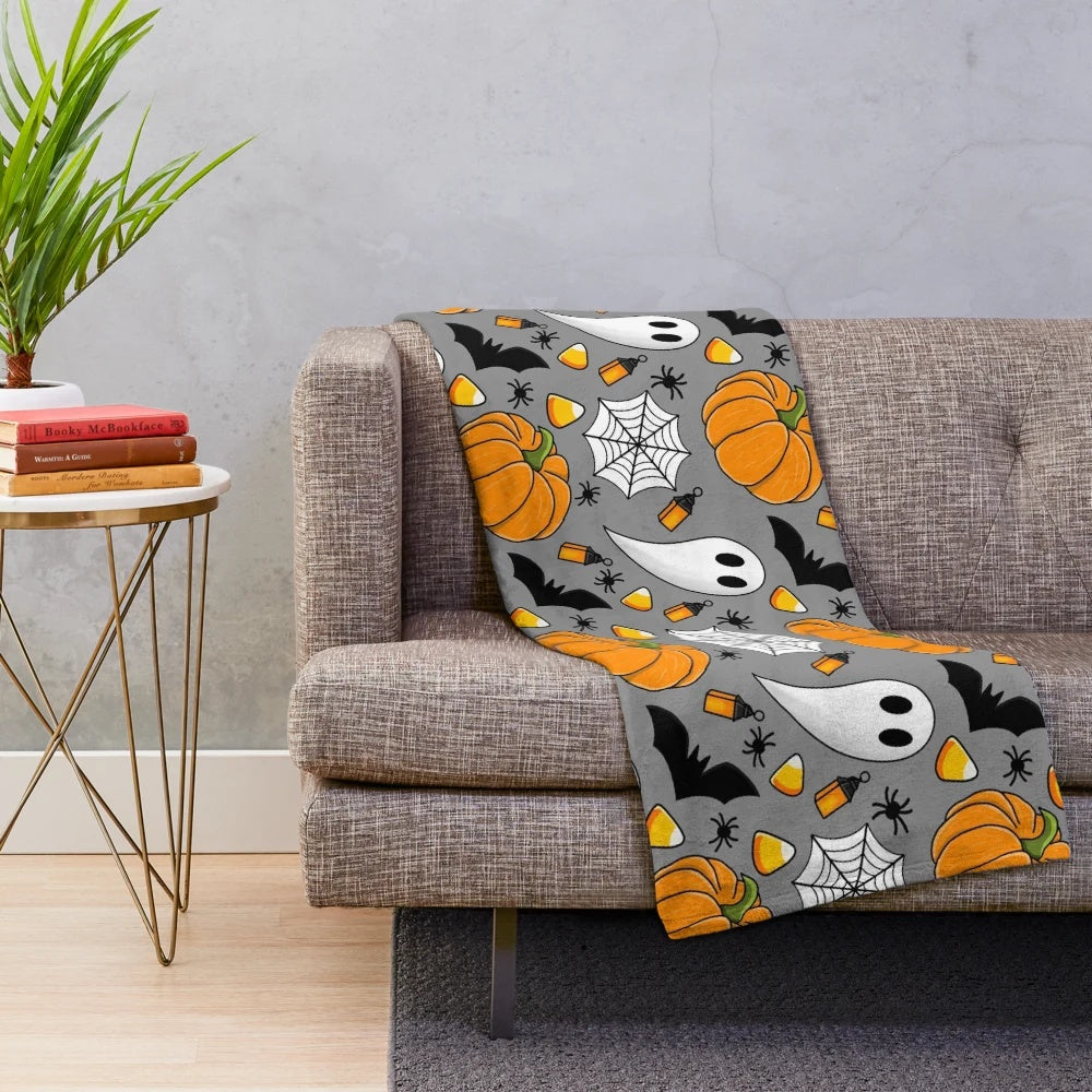 Cozy Halloween patterned plush blanket with pumpkin, spider web, candy corn, and other spooky designs