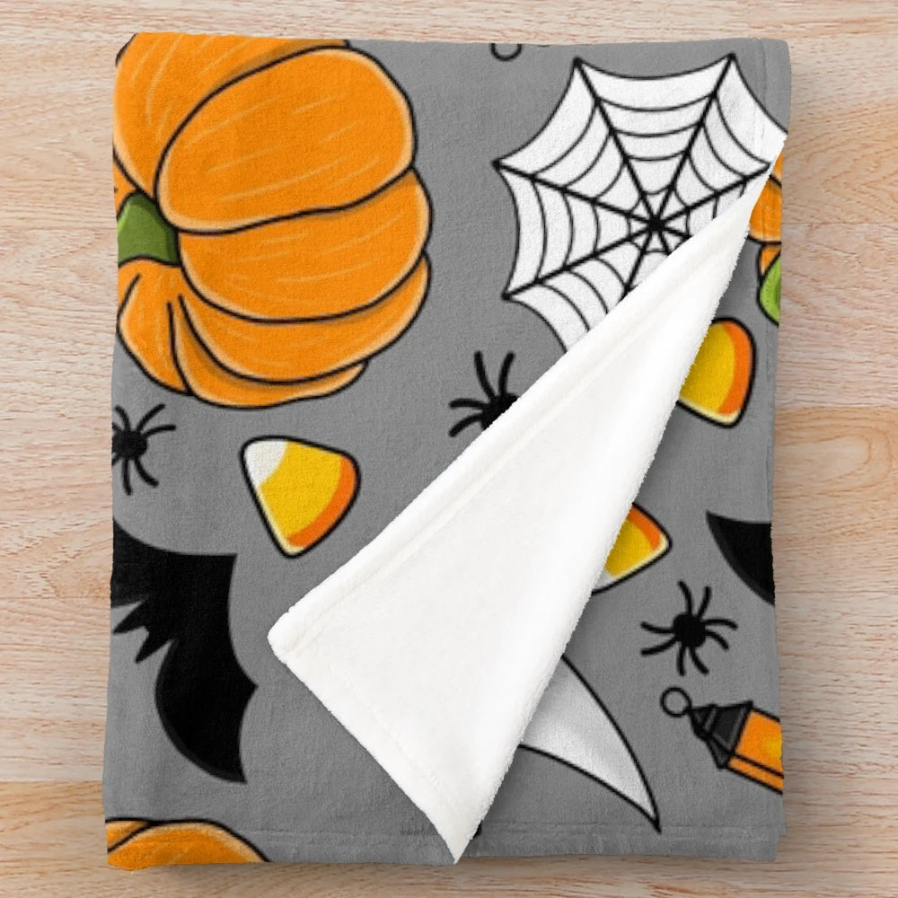 Cozy Halloween patterned plush blanket with pumpkin, spider web, candy corn, and other spooky designs