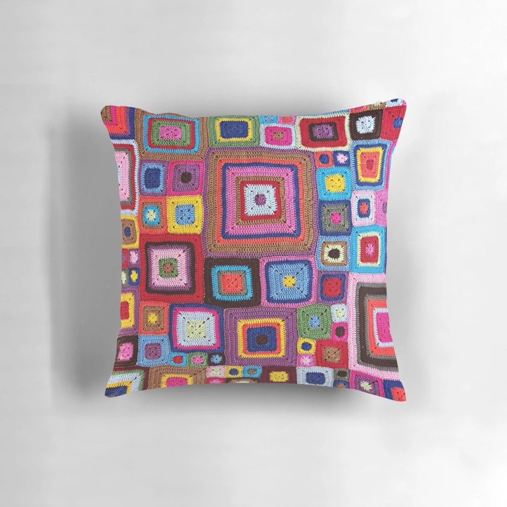 A cozy, handmade crochet pillow in a vibrant vintage granny chic style.