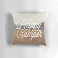 A cozy "Happy Camper" decorative pillow featuring a nature-inspired collage design with mountains, landscapes, and hiking elements.