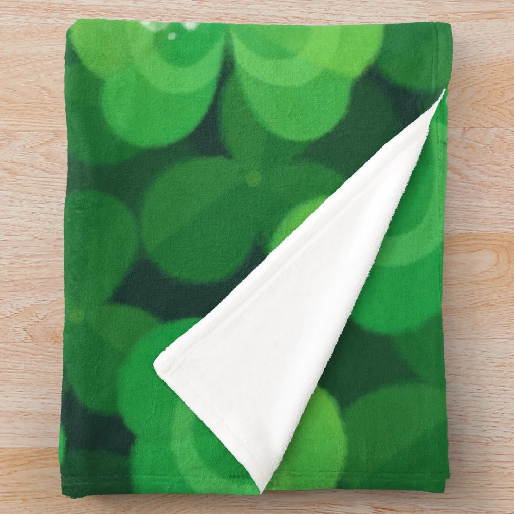 A cozy and soft plush blanket featuring a happy and lucky snail design with 4 leaf clovers and plants.