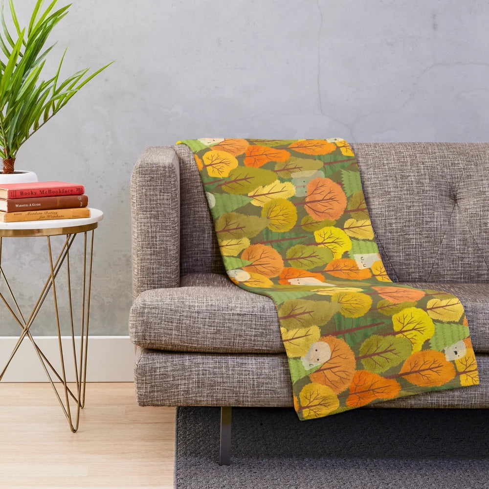 Plush blanket with a design of cute ghosts and trees in an autumnal forest