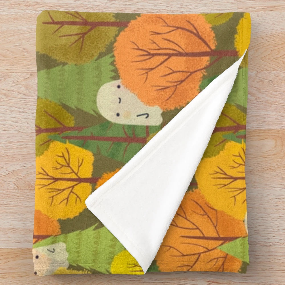 Plush blanket with a design of cute ghosts and trees in an autumnal forest