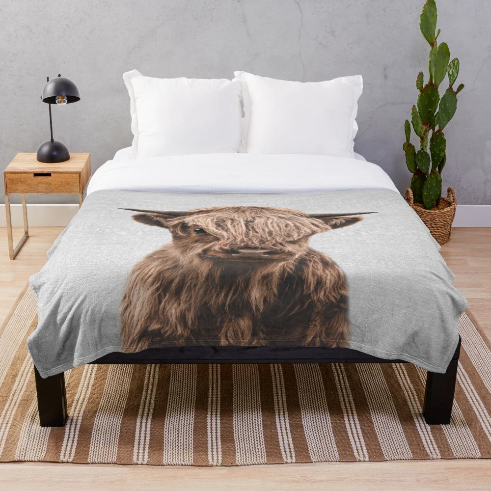 Soft and cuddly plush blanket featuring a cute highland calf design