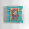 Colorful tartan pattern pillow featuring a friendly highland cow design