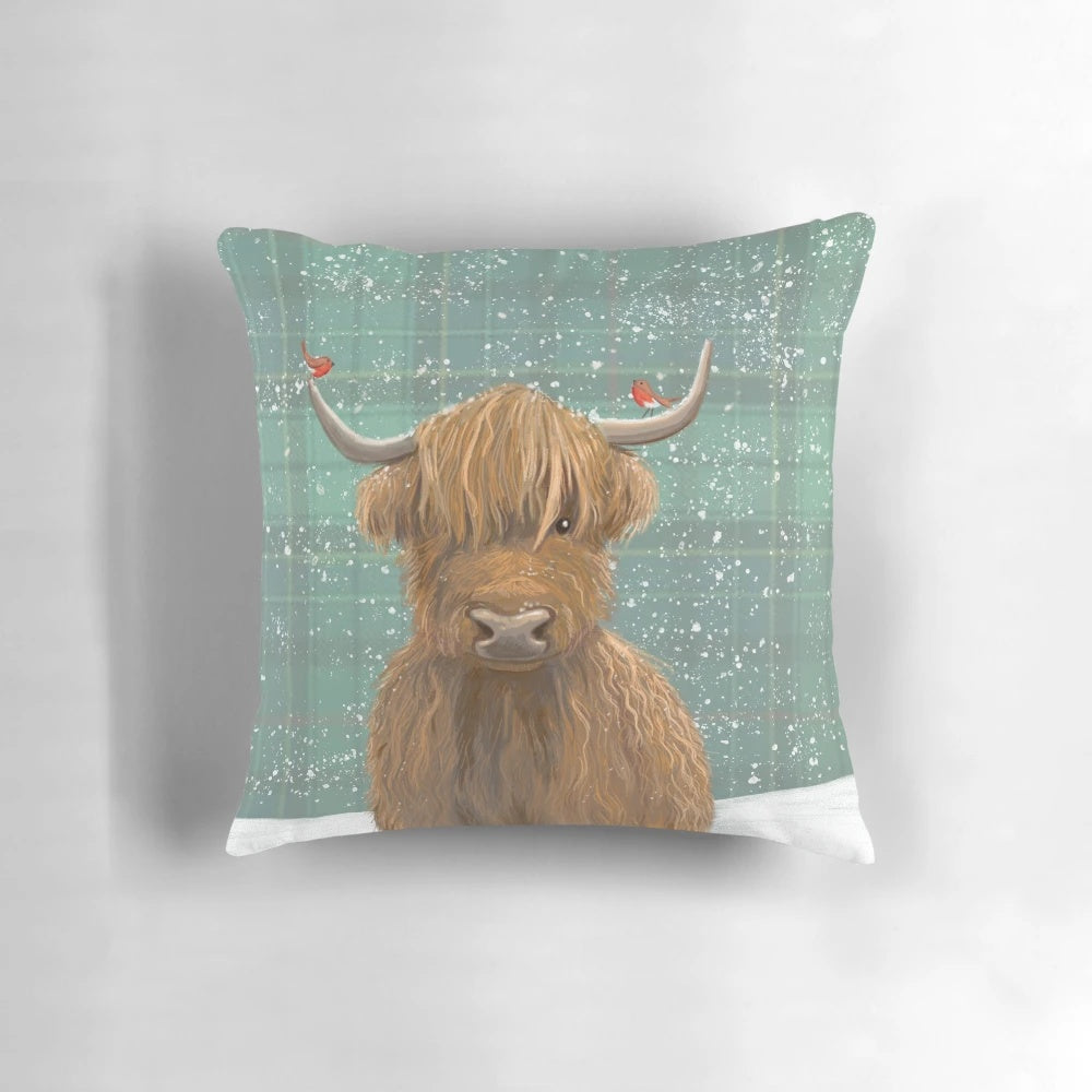 A plush, high-quality pillow featuring a highland cow in a snowy tartan pattern with robins.